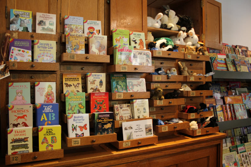 Sticker books and stuffed animals displayed in cabinet
